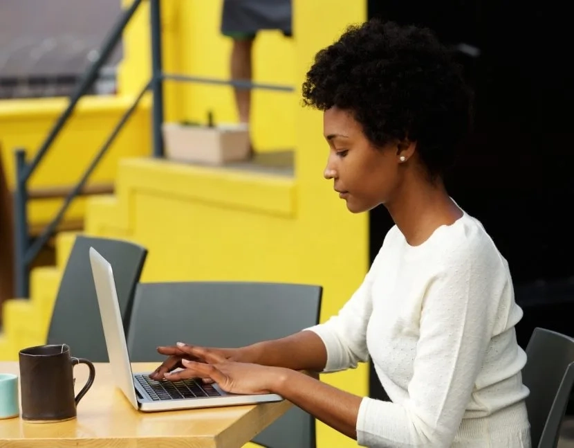 attractive-young-woman-using-laptop-outside-P9RLFGU_2x-830x647